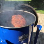 Whole brisket cooking on BBQ/ Smoker